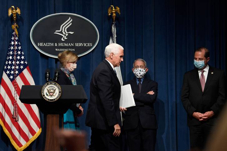 Vice President Mike Pence, second from left, walks off of the stage following the conclusion of a briefing with the Coronavirus Task Force at the Department of Health and Human Services in Washington, . Dr. Deborah Birx, left, Dr. Anthony Fauci, second from right, and Health and Human Services Secretary Alex Azar, right, are in the background.